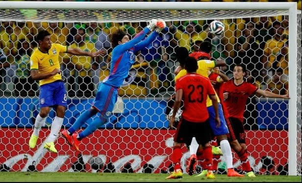 Arquero Guillermo Ochoa despeja ataque de brasileños. Ap
