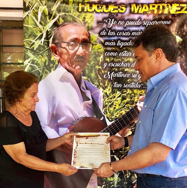 Rodolfo Molina Araújo, entrega Nota de Estilo a Katia Montero, donde se exalta la vida y obra del fallecido guitarrista Hugues Martínez Sarmiento